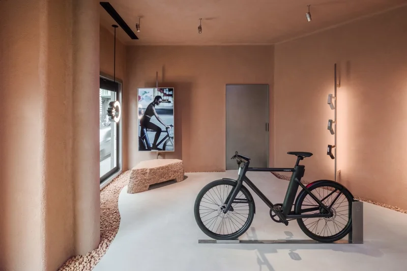 A photograph. The interior of Cowboy brand store in Paris. A single C4 is visible, standing in a minalist room with pastel poink decor.