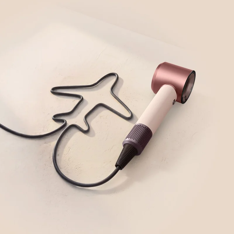 Dyson Supersonic Travel hair dryer with the cable shaped to resemble an airplane