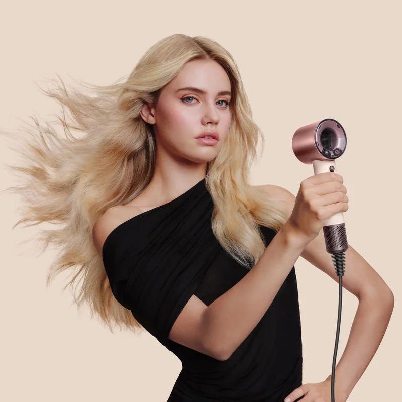 Model uses the Dyson Supersonic Travel hair dryer to dry her hair
