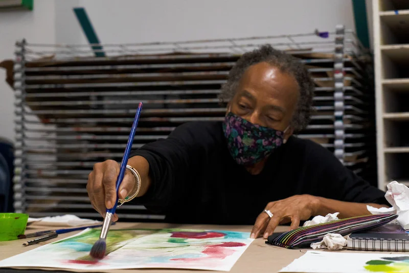 A woman using a paintbrush and paint