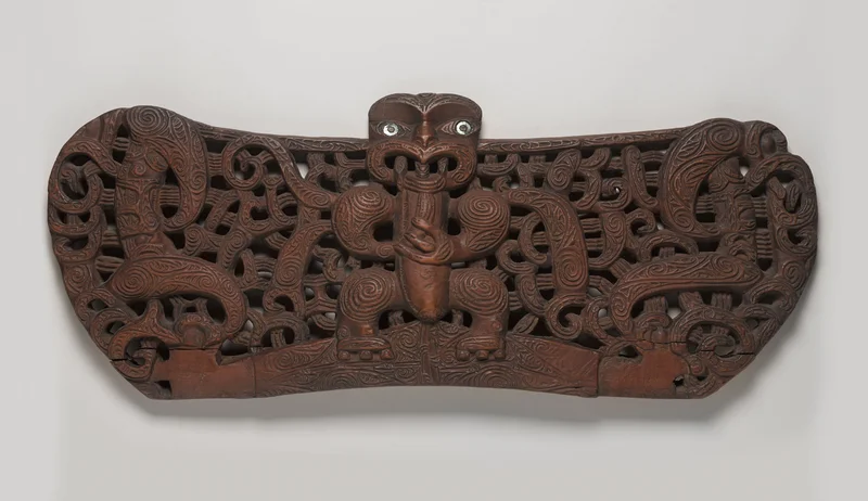 A piece of wood carved with intertwined lines around a central figure