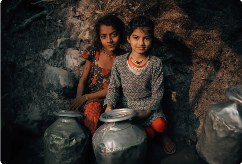 2 girls in Nepal hold water containers