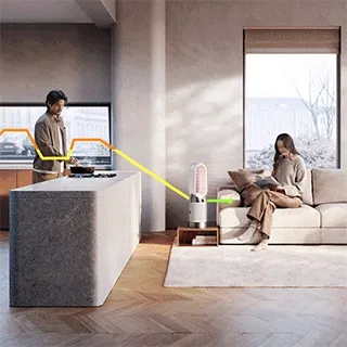 A Dyson Heating Purifier cleans air in a room while a person cooks on a gas stove