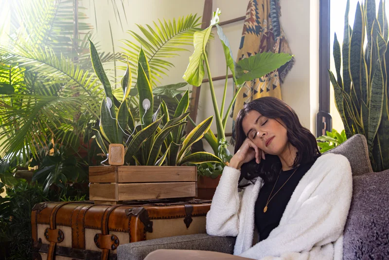 woman surrounded by plants and listening to plant music