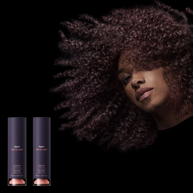 Model with curly hair next to the Dyson Chitosan styling Pre-style cream and Post-style serum.