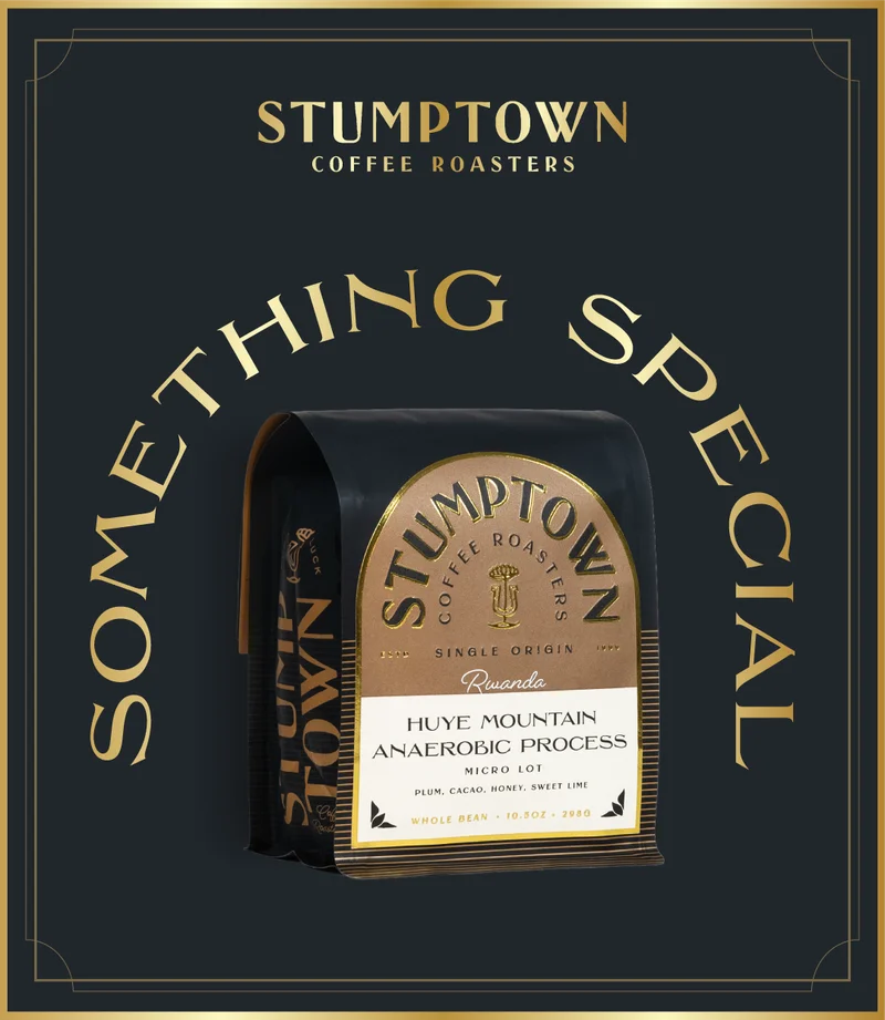 Stumptown Coffee Roasters Huye Mountain Anaerobic Process coffee bag on a dark background, featuring a black package with a gold label and arched “Something Special” text surrounding it.