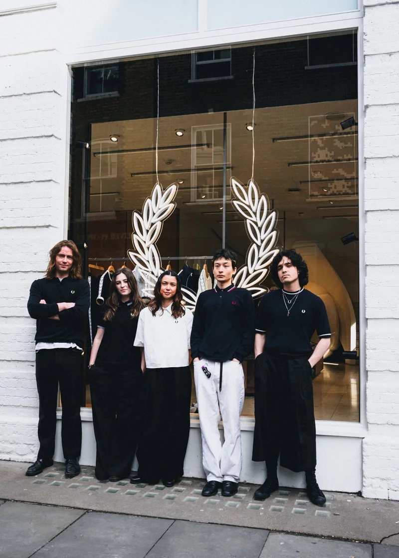 Photograph of five store staff outside the front of the store.