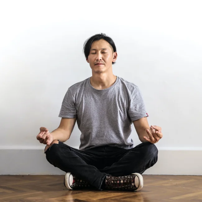 A man relaxes in a meditative pose.