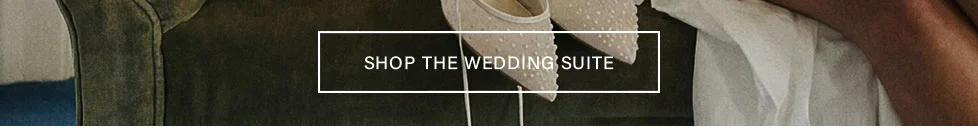 Elegant ivory bridal flats with textured dots, white dress, and green fabric. Shop the Wedding Suite for stylish wedding day essentials.