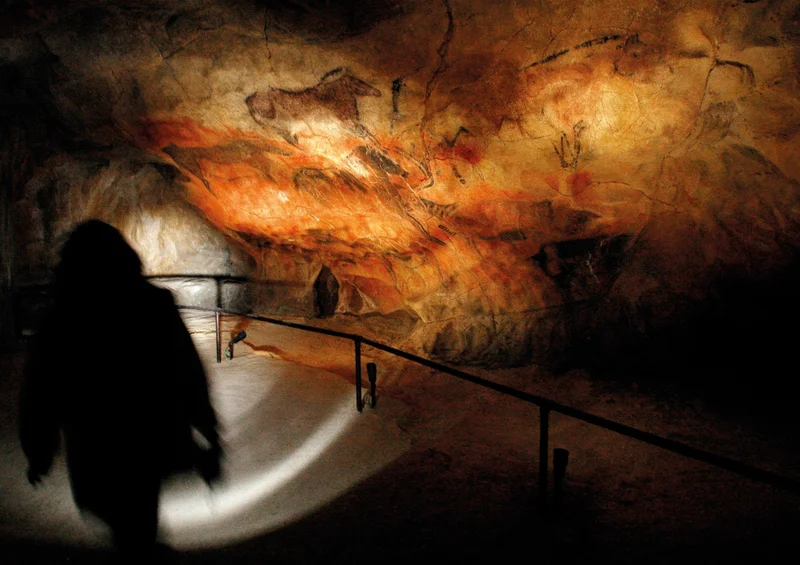A photo of the main panel at the Tito Bustillo cave depicting Paleolithic cave drawings of deer, horses, and reindeer of the period.