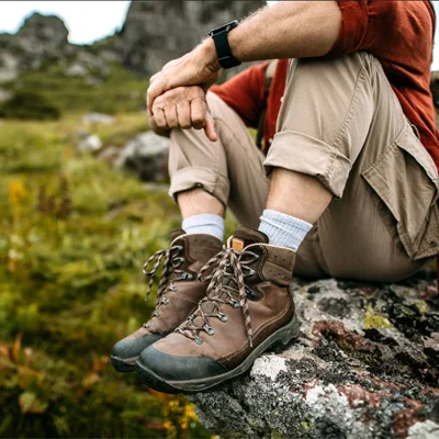 A man sitting down on a a rock enjoying a view