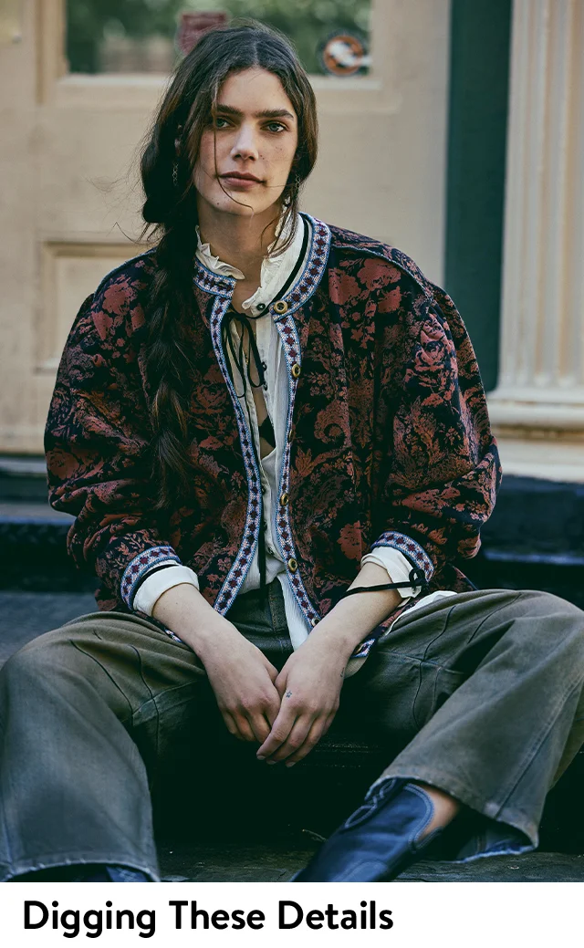 A woman wearing a floral-print jacket and ruffled-collar shirt.