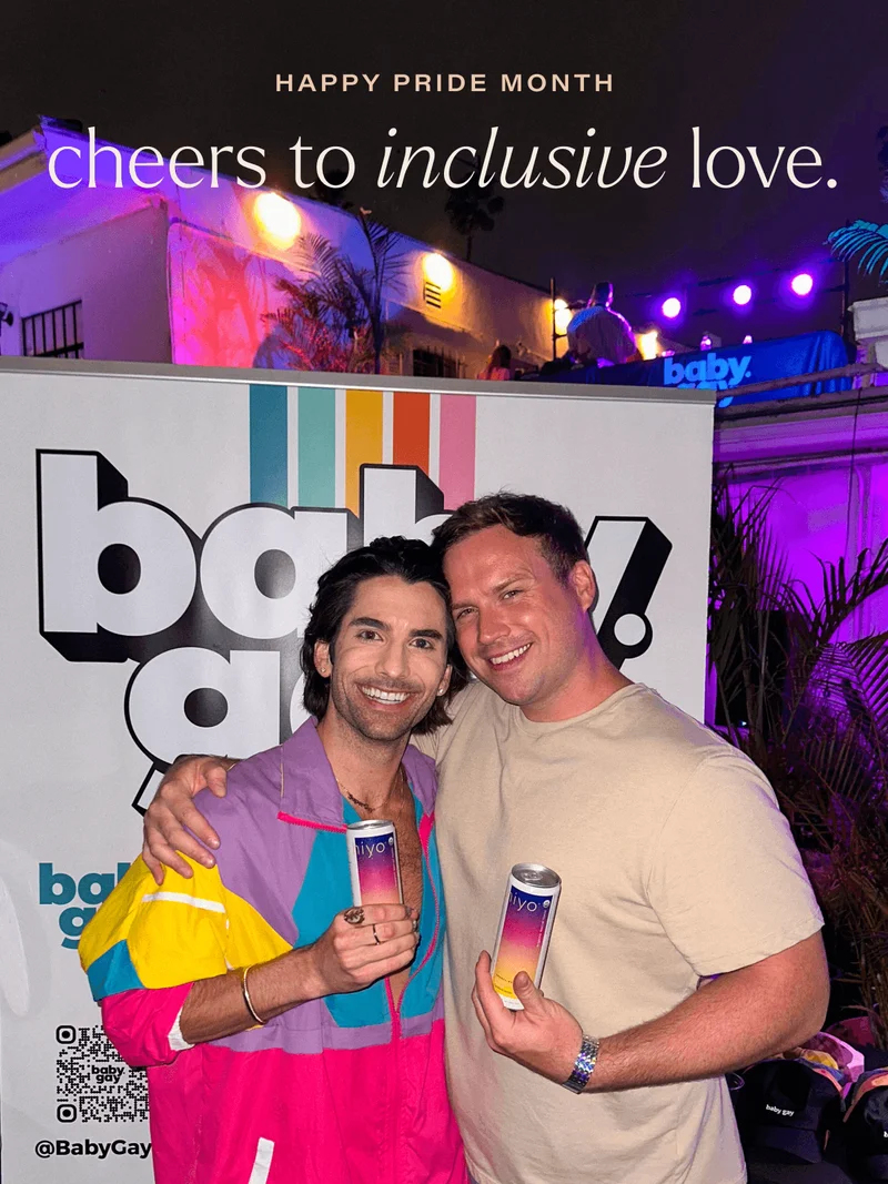 happy pride month. cheers to inclusive love. two ecstatic men hugging with hiyo in hand at a babygay event in los angeles, ca.