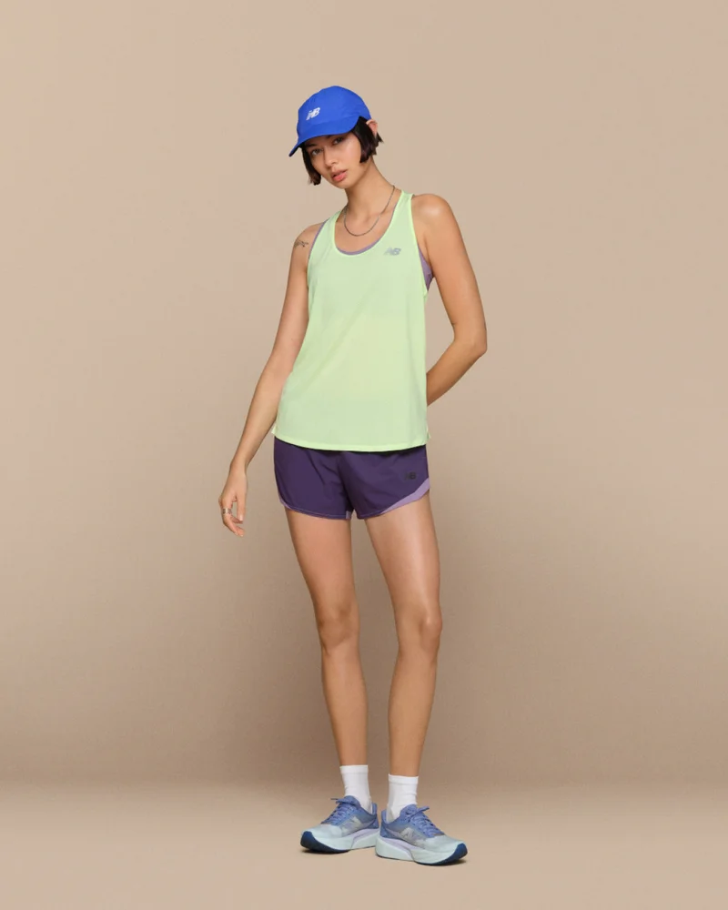 Woman pictured in New Balance shoes and apparel, including the RC Essential Tank and NB Essential Run Bra