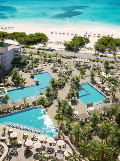 An aerial shot of a resort pool and the beach
