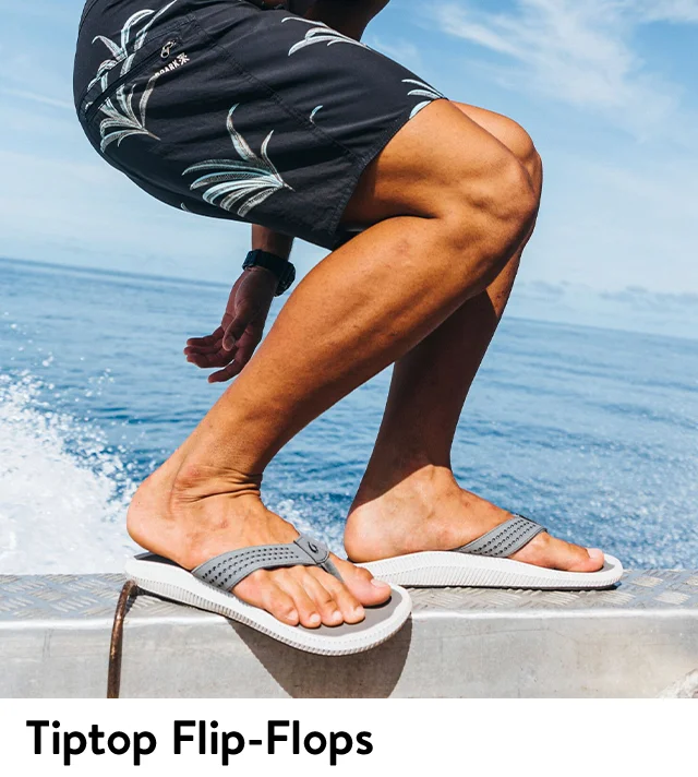 Model wearing swim trunks and flip flops.