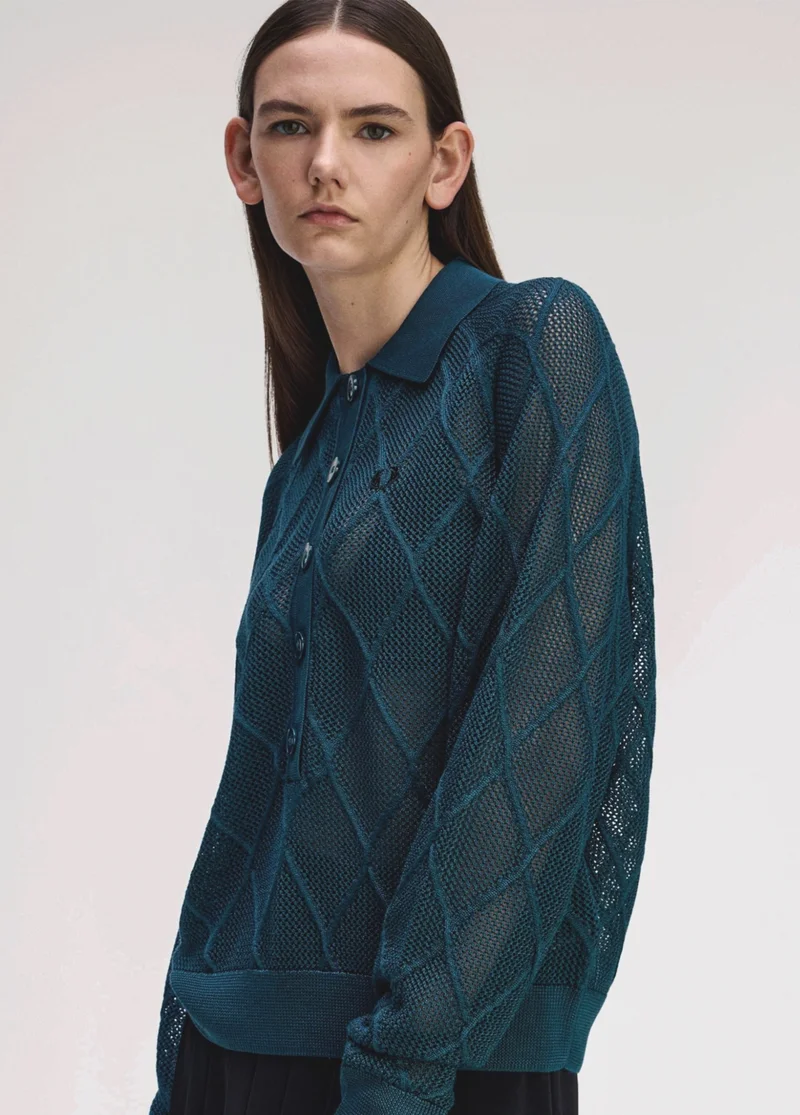 White female model wears a Fred Perry Argyle Mesh Knitted Shirt in Dark Petrol