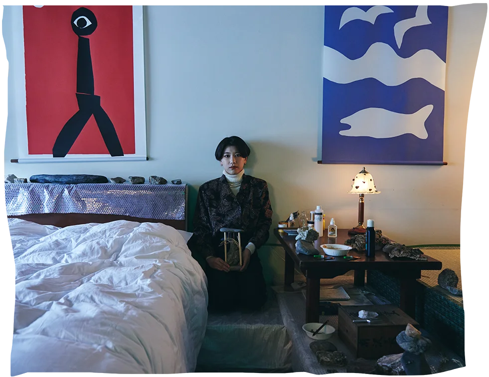 artist in hotel room art studio, with materials around the bed