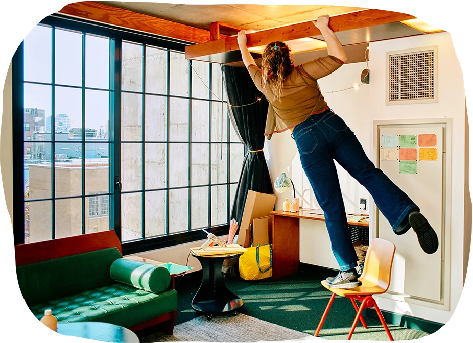 artist standing on chair in hotel room peaking into ceiling light