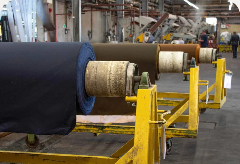 Large rolls of fabric inside a factory.