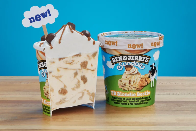 Pint of Ben & Jerry's PB Blondie Bestie Sundae cut in half so you can see the whipped topping and chunks and swirls.