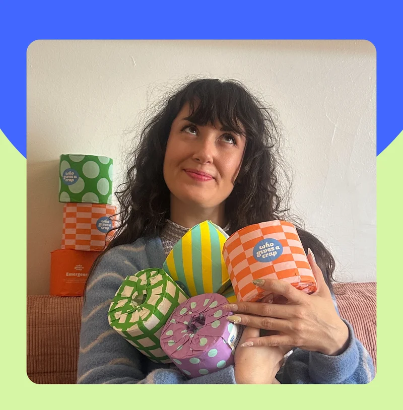 Image: Person holding various Who Gives A Crap toilet paper rolls.