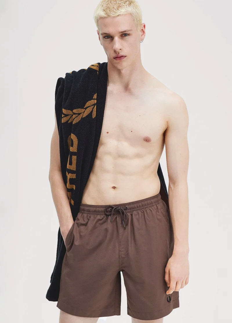 Male model wearing brown swimming shorts