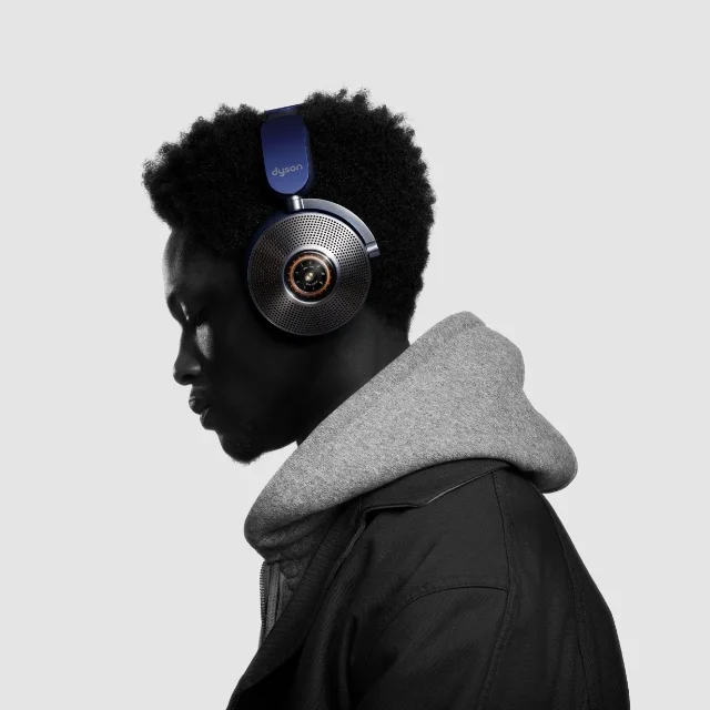 The profile of a man wearing Dyson Zone™ noise-cancelling headphones in Prussian blue