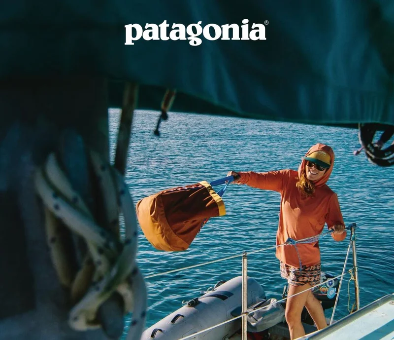Patagonia. A person in a dinghy throws a bag onto the deck of a sailboat.
