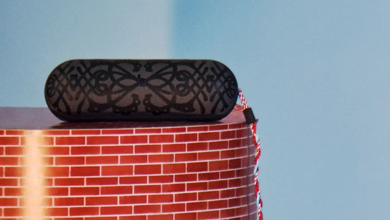 Kiko Kostadinov Beats Pill speaker shown with custom grill design in gray and colorful braided lanyard