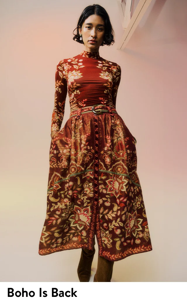 A woman wearing a floral-print turtleneck top with a matching skirt.