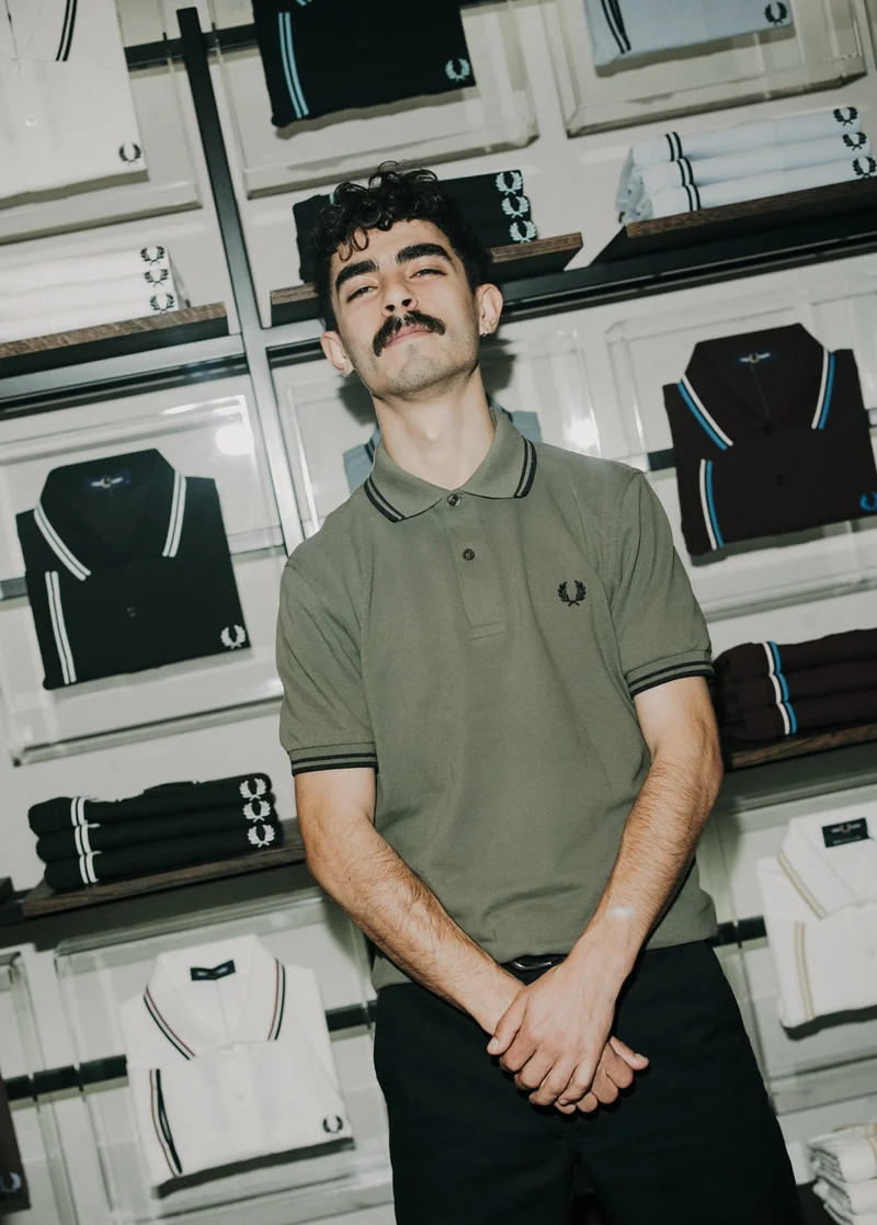 Male wearing a M3600 Twin Tipped Fred Perry Shirt in Laurel Wreath Green / Black / Black