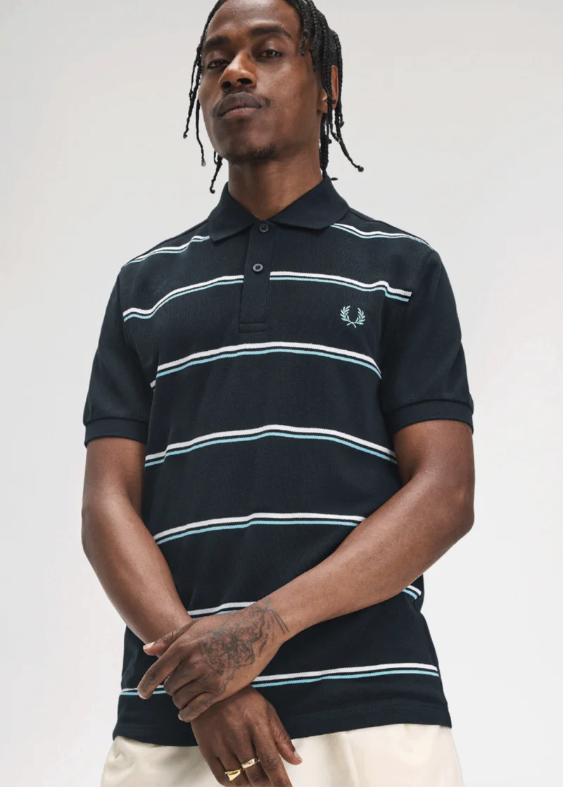 Black male model with braids and hand tattoo wears a navy polo with thin pale blue and white stripes