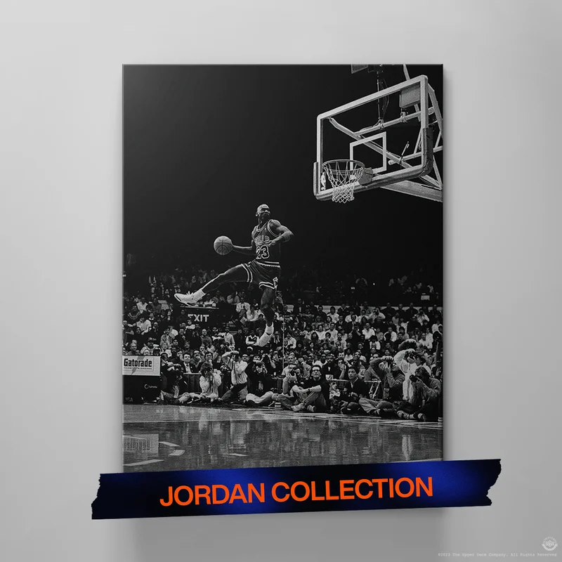 Black-and-white canvas of a basketball player soaring mid-air for a dunk in front of a cheering crowd. Text below reads ‘Jordan Collection’ in orange. Black-and-white canvas of a basketball player soaring mid-air for a dunk in front of a cheering crowd. Text below reads ‘Jordan Collection’ in orange.