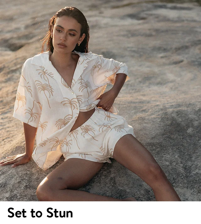 A woman wearing a palm-printed top with matching shorts.