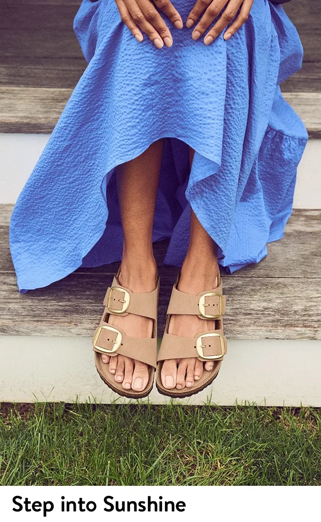 Women wearing slide sandals with buckles.