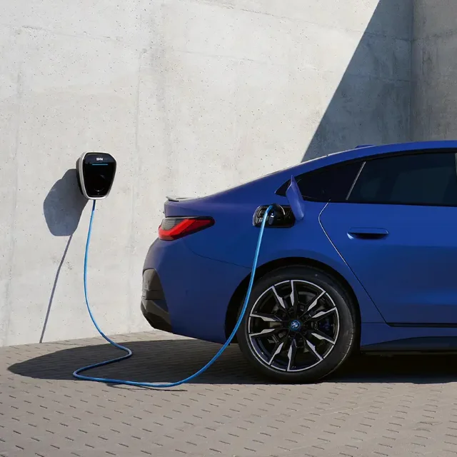Blue BMW sedan charging at home via BMW Wallbox.