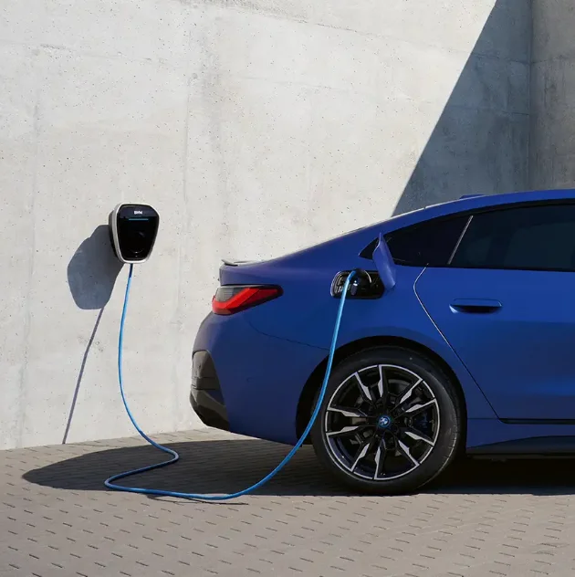 Blue BMW sedan charging at home via BMW Wallbox.