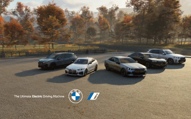 BMW vehicles parked in a lot with scenic foliage.
