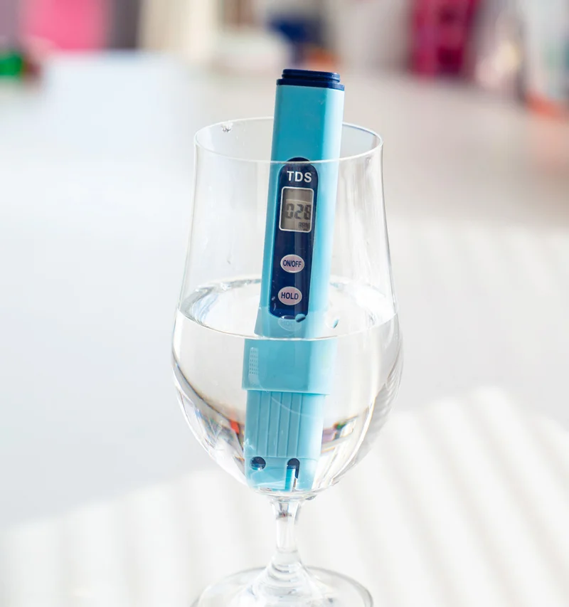 TDS meter in a glass of water