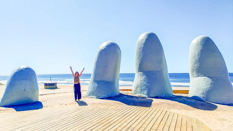 Image description: Woman posing for photo at Mano de Punta del Este, Uruguay.