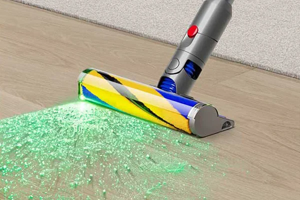 A green blade of light emits from the Fluffy Optic cleaner head on a hard floor