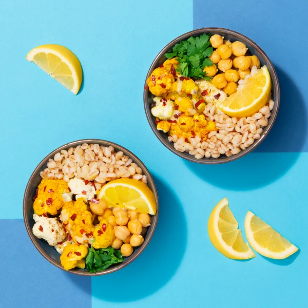 Two bowls of roasted cauliflower, chickpea and barley salad