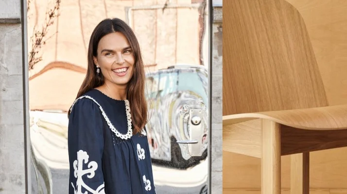 Photo of HAY Co-Founder Mette Hay smiling and looking off to the side wearing a navy blue and white dress.