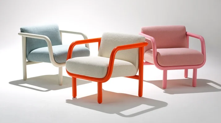 Whitesweep of three NaughtOne Percy Lounge Chairs in light blue upholstery with white arms and legs on the right, white upholstery with orange arms and legs in the center, and pink upholstery with pink arms and legs on the right.