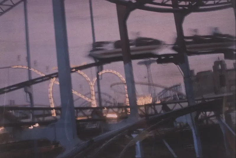 A blurred photo of a roller coaster at dusk
