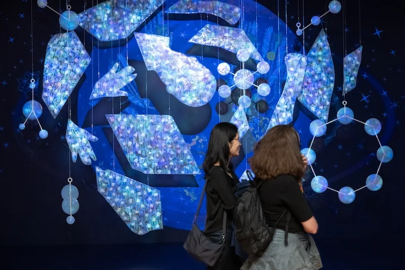 Two people looking at blue abstract art