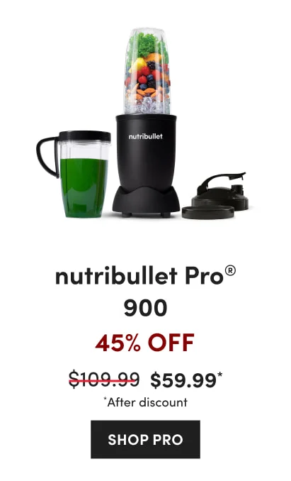 Black nutribullet blender filled with fruits, vegetables, almonds, and ice with a mug with green smoothie and two lids.