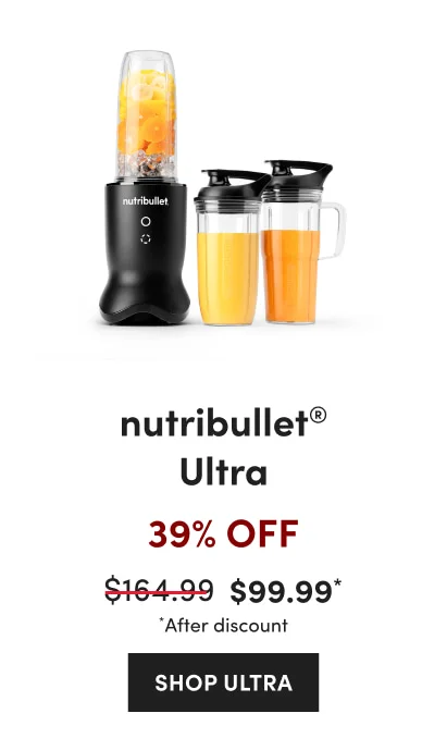 A black nutribullet blender filled with orange and banana slices, ice, and two additional filled cups on a white background.