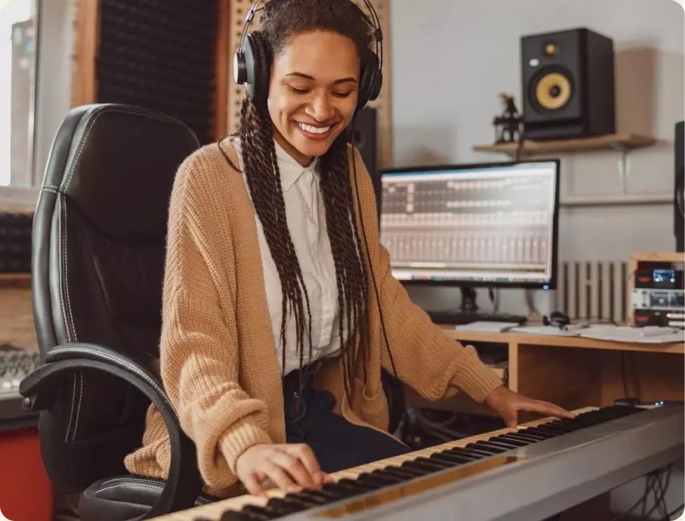 Person wearing headphones playing electronic piano